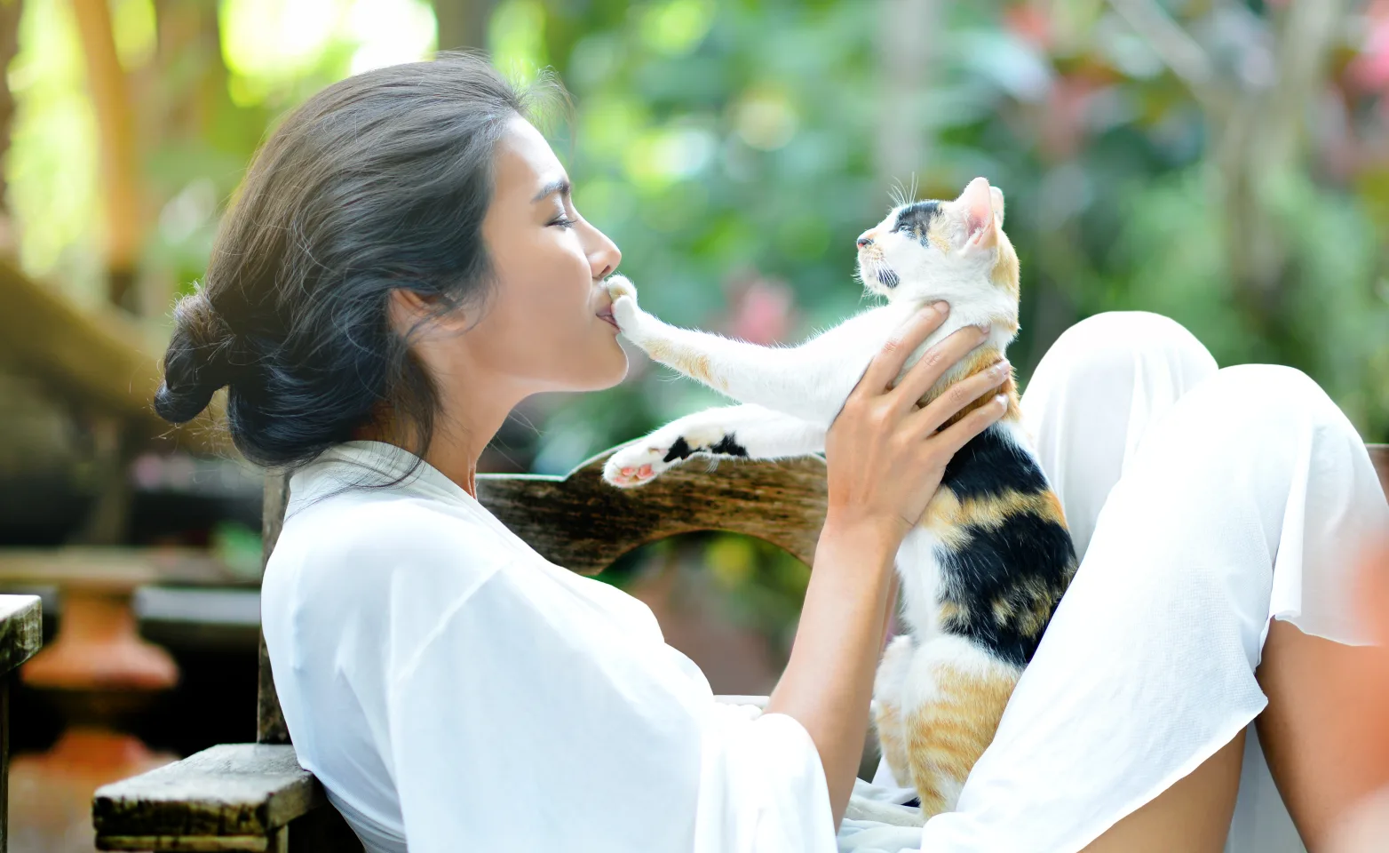 Woman with cat outside sitting down